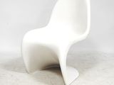 une chaise en plastique blanche posée sur un sol blanc