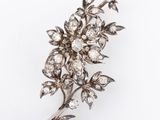 a close up of a diamond flower broochle on a white background