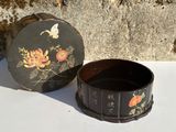 une petite boîte noire ornée d'un motif floral