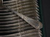 a lot of silver spoons and spoons on a tray