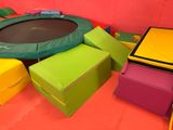 a trampol in the middle of a room filled with colorful boxes