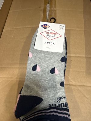 quelqu'un tient une paire de chaussettes qui se trouve dans une boîte