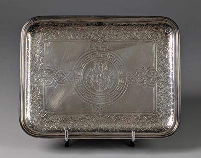 an antique silver tray with a design on the front