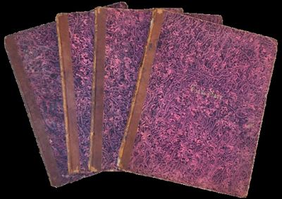 trois livres violets à la couverture marron sont empilés les uns sur les autres