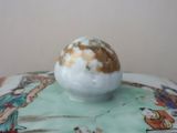 a white bowl with a brown and white ball on top of it