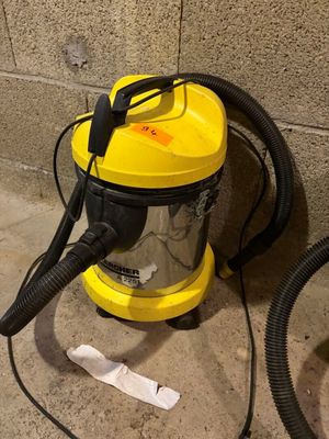 un aspirateur jaune et noir posé par terre près d'un mur