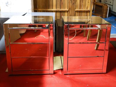pair of mirrored nightstands with drawers and drawers on red carpet