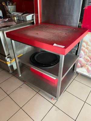 une table rouge sur laquelle est posée une assiette noire, dans une cuisine