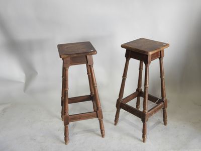 deux tabourets en bois placés l'un à côté de l'autre sur une surface blanche