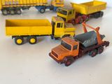 Plusieurs camions miniatures sont alignés en cercle sur une surface blanche