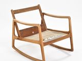 a wooden rocking chair with a leather seat on a white background