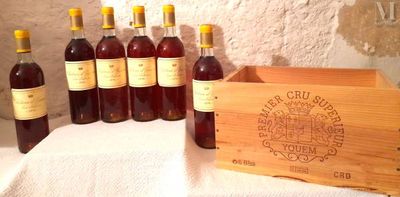 plusieurs bouteilles de vin dans une caisse en bois posée sur une table