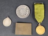 two medals, a medal, and a piece of paper on a table