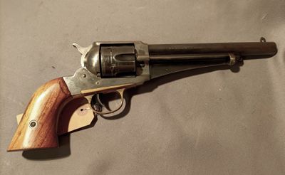 an old revolver with a wooden handle on a white surface