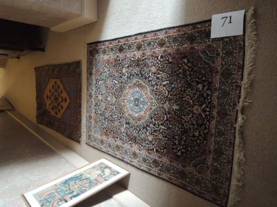 un tapis sur le sol à côté d'un tableau sur le mur