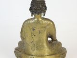 statue of a seated buddha sitting on a white surface