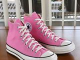 pink converses on a wooden table with a window in the background
