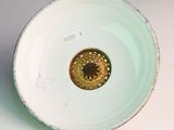 a white bowl with a yellow flower inside of it