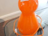 une lampe orange posée sur une table en verre