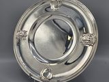 a silver plate with a lion head design on the rim