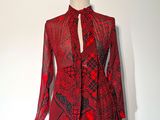 une robe rouge et noire posée sur un présentoir pour mannequin