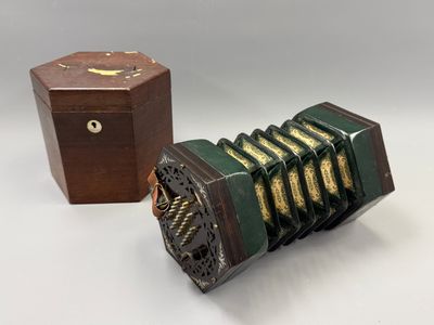 une image représentant un vieil accordéon et une boîte en bois posés sur une table