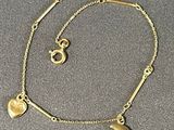 un bracelet en or orné d'un pendentif en forme de croissant et d'un pendentif en forme de cœur