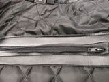 a close up of a black quilted jacket with a zipper