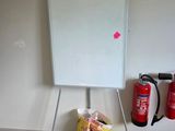 un tableau blanc posé sur un support, dans un coin de la pièce
