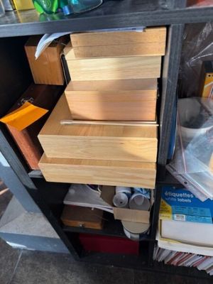 une pile de livres sur une étagère, à côté d'une bouteille d'eau