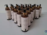 six bottles of liquid sitting on top of a white table