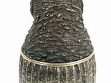 a vase with a bear head on it on a white surface