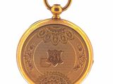 a gold pocket watch with a medallion on it