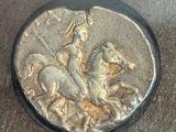 a silver coin with a picture of a man on a horse