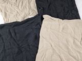 three different colors of knitted pillows on a white surface
