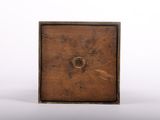 an old wooden box with a hole in it on a white surface
