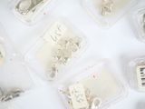 many different types of jewelry in plastic containers on a table