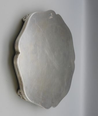 an antique silver plate mounted on a wall with a mirror