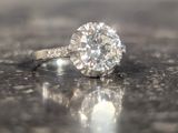 a diamond ring sitting on top of a shiny surface