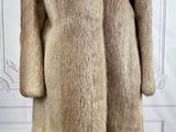une photo d'un manteau de fourrure posé sur un support de mannequin