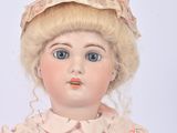 a doll with blonde hair wearing a pink dress and a hat