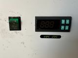 a white refrigerator with a digital clock on the front
