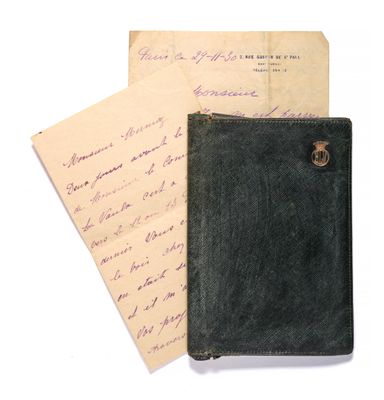 un vieux portefeuille noir posé sur une feuille de papier, à côté d'une autre feuille de papier