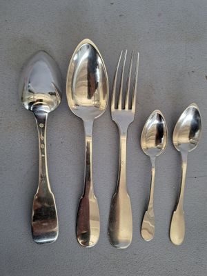 cinq cuillères en argent et deux cuillères en argent sur une table