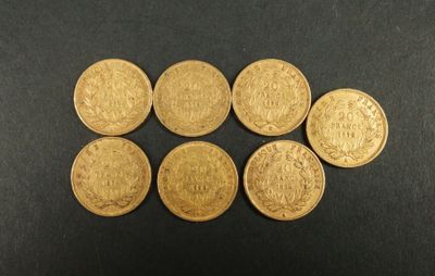six souverains d'or britanniques alignés sur une surface noire