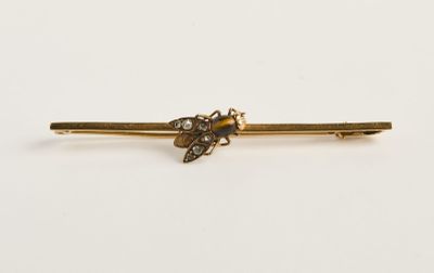 un gros plan sur une barrette dorée ornée d'une fleur