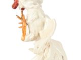 a statue of a rooster holding a carrot in its hand