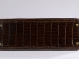 brown alligator skin wallet with gold buttons on a white background