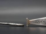two pieces of silver metal are laying on a table