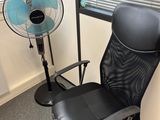 a black office chair with a fan next to it